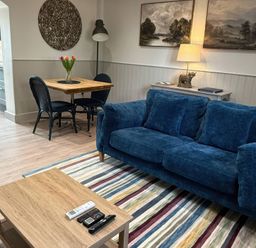 A living room with a sofa, table, and chairs at Foxglove in Stratton Audley near Bicester