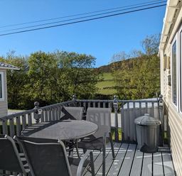 An outdoor area with a table and chairs at Clarach Bay Holiday Village W18 in Aberystwyth
