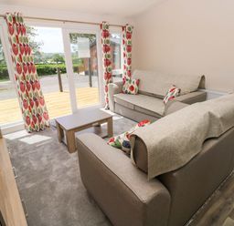 A living room with sofas and a coffee table at Sandpiper in Narberth