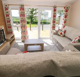 A living room with a sofa and coffee table at Sandpiper in Narberth