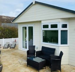 A house with a deck and chairs at O7 in Abersoch