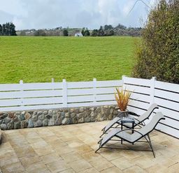 An outdoor area with loungers and a view of the lawn at O7 in Abersoch