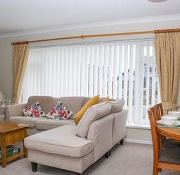 A living room with sofa and dining area at Halsdon Avenue in Exmouth