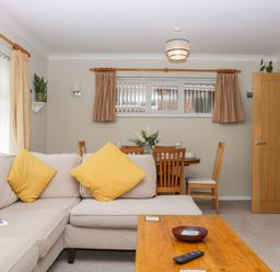 A living room with a sofa and dining area at Halsdon Avenue in Exmouth