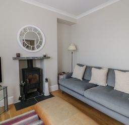 A living room with a sofa and fireplace at Arosfa New Quay