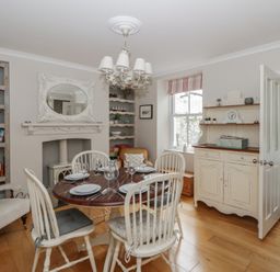 A dining room with a table and chairs at Arosfa in New Quay