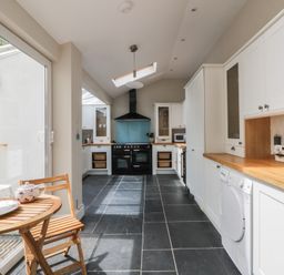 A kitchen with cabinets and appliances at Arosfa in New Quay