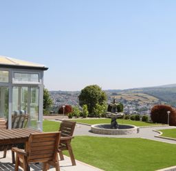 A garden with a conservatory and an outdoor table at The White House in Okehampton