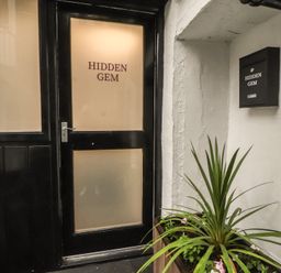 An entrance door with a nameplate at Hidden Gem