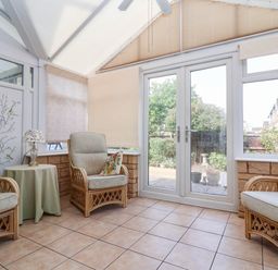 A conservatory with armchairs and a table at Number 10, Broadway
