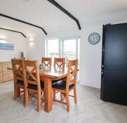 A dining room with a wooden table and chairs at Little House in Wadebridge