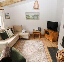 A living room with a sofa and television at The Old Dairy near Solva