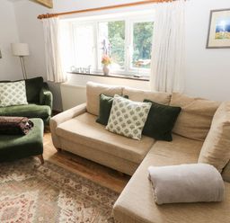 A living room with a sofa and armchair at The Old Dairy near Solva
