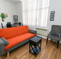 A living room with a sofa and armchair at Ocean Breeze in Weymouth