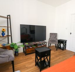 A living room with a television and seating area at Ocean Breeze in Weymouth