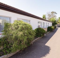 A pathway alongside a building with bushes at Cottage 1 Tenby