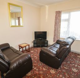 A living room with two sofas and a television at Cottage 1 in Tenby