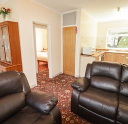 A living room with a sofa and cabinets at Cottage 1 in Tenby