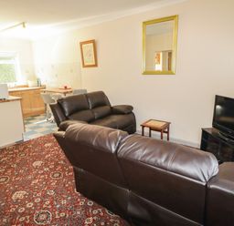 A living room with a couch and tv at Cottage 1 Tenby