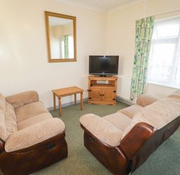 A living room with sofa and television at Cottage 3 in Tenby