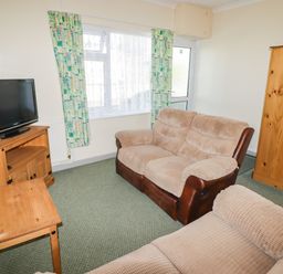 A living room with a television and seating at Cottage 3 in Tenby