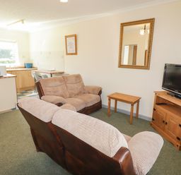 A living room with a couch and television at Cottage 3 in Tenby
