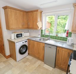 A kitchen with appliances and green tiles at Ti Maolla in Hollymount