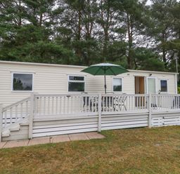 A mobile home with a deck and table at Foxglove 4 Ringwood