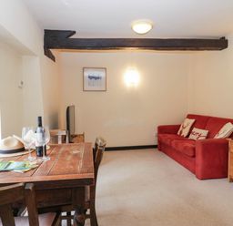 A living room with a dining table and sofa at Flat 4 Grasmere Lodge in Ambleside