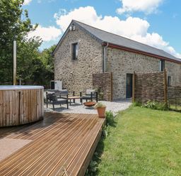 A garden with a hot tub and seating area at Reddaway Byre Okehampton