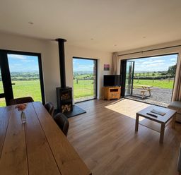A living room with a dining table and a television at High View Barn in Launceston