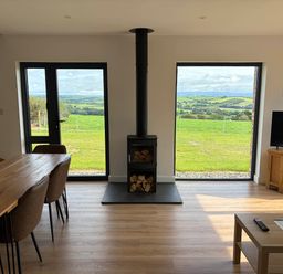A living room with a dining table and wood stove at High View Barn in Launceston