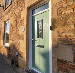 A front door with a window and brick wall at Corner House Wark