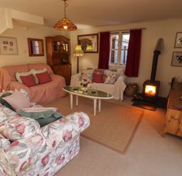 A living room with sofas and a stove at 11b Market Street in Narberth