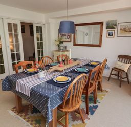 A dining room with a table set for meals at 11b Market Street Narberth