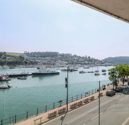A view of boats on the water and a street lined with benches at 5 Sails Dartmouth