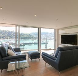 A living room with a view of the harbor at 5 Sails in Dartmouth