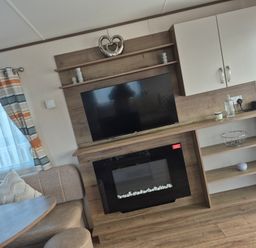 A living room with a television and fireplace at Unity Beach in Burnham-on-Sea