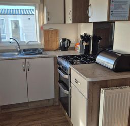 A kitchen with a sink, stove, and utensils at Unity Beach - Abi Ryedale in Burnham-on-Sea