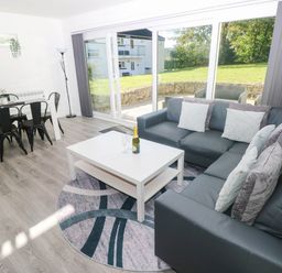 A living room with a sofa table and dining area at Coedrath Park