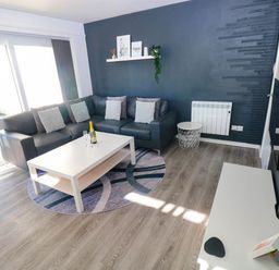 A living room with a sectional sofa and coffee table at Coedrath Park