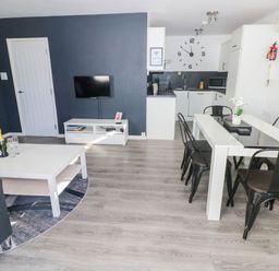 A living room with a sofa and dining area at Coedrath Park 