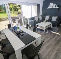 A living room with a sofa, dining table, and coffee table at Coedrath Park