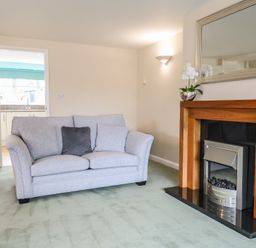 A living room with a sofa and a fireplace at Frome View Wool