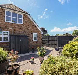A garden with a paved area and shed at Frome View in Wool