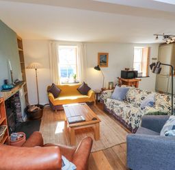 A living room with a sofa and coffee table at Scoops’ Nook in Caernarfon