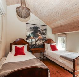 A bedroom with two beds and a table at The Coach House Cottage BALLYCOMMON