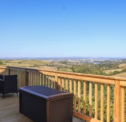 An outdoor deck with chairs and a table overlooking a landscape at Lodge 19 Millbrook