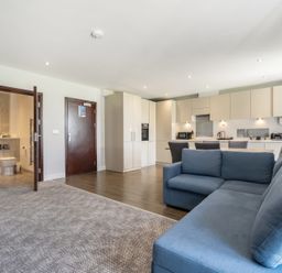 A living room with a sofa and kitchen area at Cotswolds Apartment, sleeps 4 in Chipping Norton