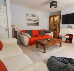 A living room with a sofa, coffee table, and television at Driftmark in Weymouth